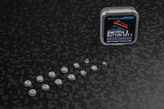 Set of aluminum switch buttons with packaging on a textured black surface
