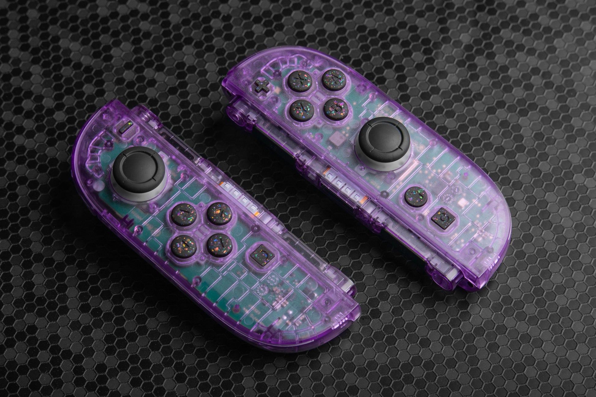 Purple joycons with colorful black buttons on a dark background