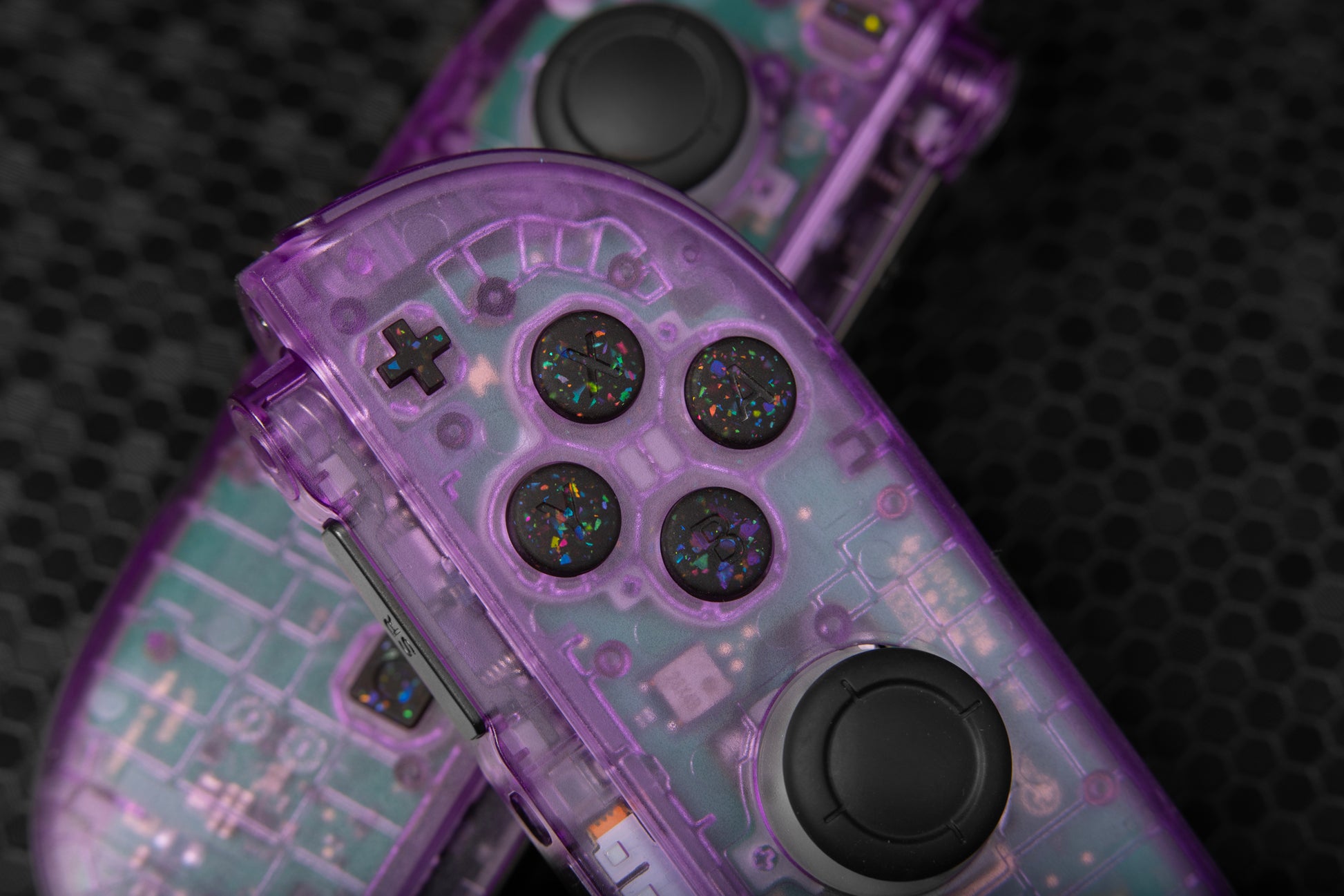 Close-up of a purple joycons with transparent top, party black confetti buttons installed