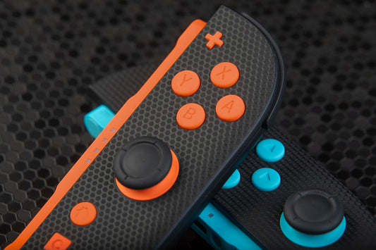 Close up of joycons with color matched orange and blue buttons installed 